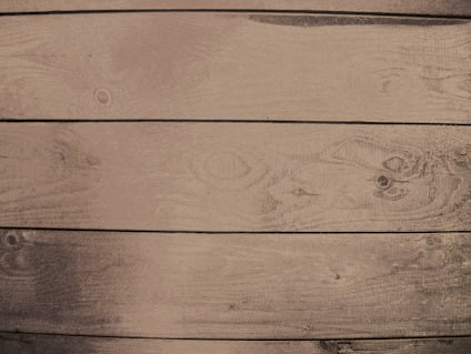 Bruna träplankor med ådring och knastar synliga i närbild.