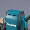 Makita handöverfräs med blått och svart hölje, delvis synligt på en arbetsyta.