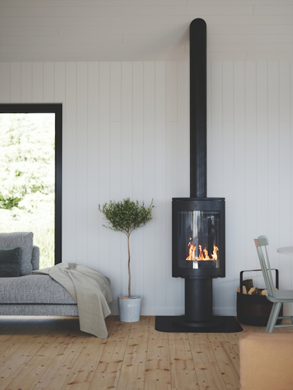 En modern svart kamin med glasfront och synliga lågor, placerad i ett ljust vardagsrum med parkettgolv och vita väggar.