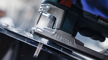 Sticksåg från Bosch skär genom en svart yta.