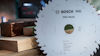 Sågklinga märkt "Bosch PRO Wood" med träplankor i bakgrunden.